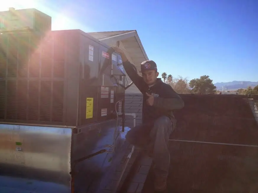 HVAC technician performing AC Tune-Up on a rooftop unit in Charter Oak